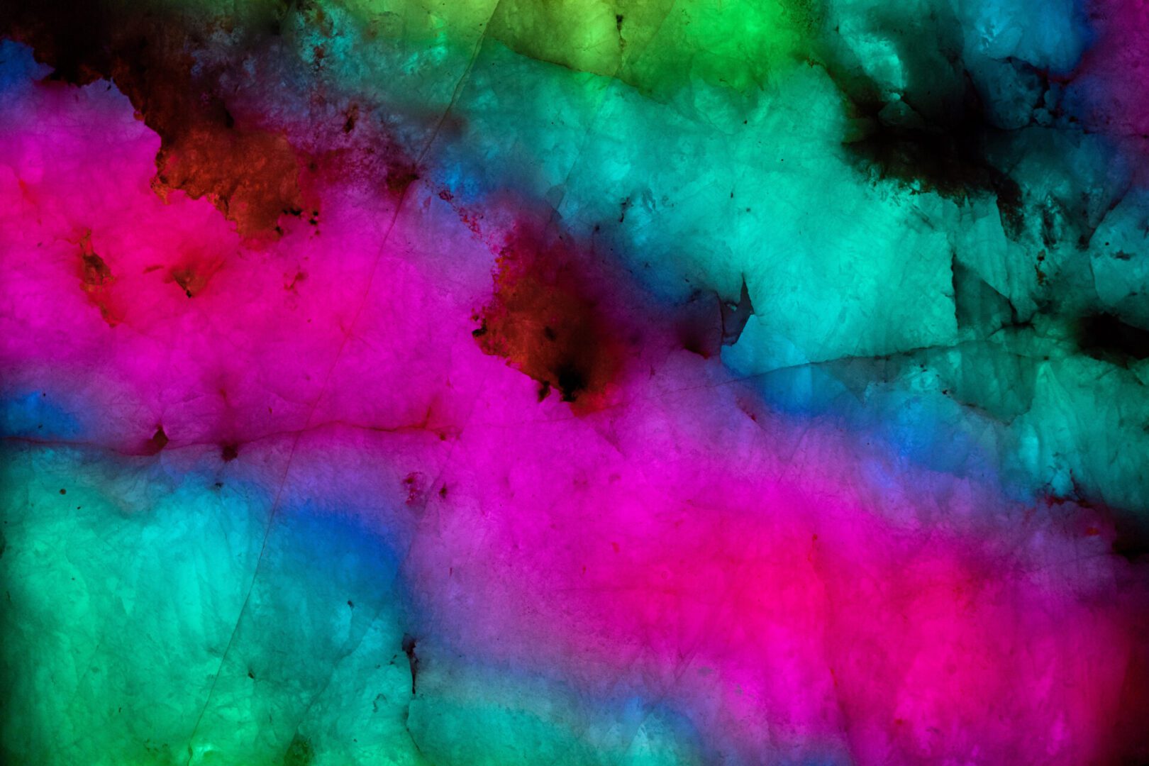 Vibrant abstract texture with swirling colors in green, blue, pink, and black.