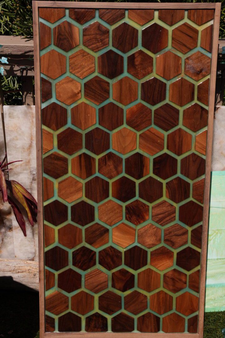 Decorative honeycomb-patterned metal screen with plants behind.