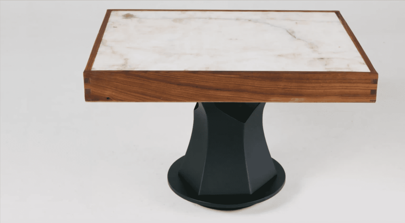 Modern square table with marble top and black geometric base.