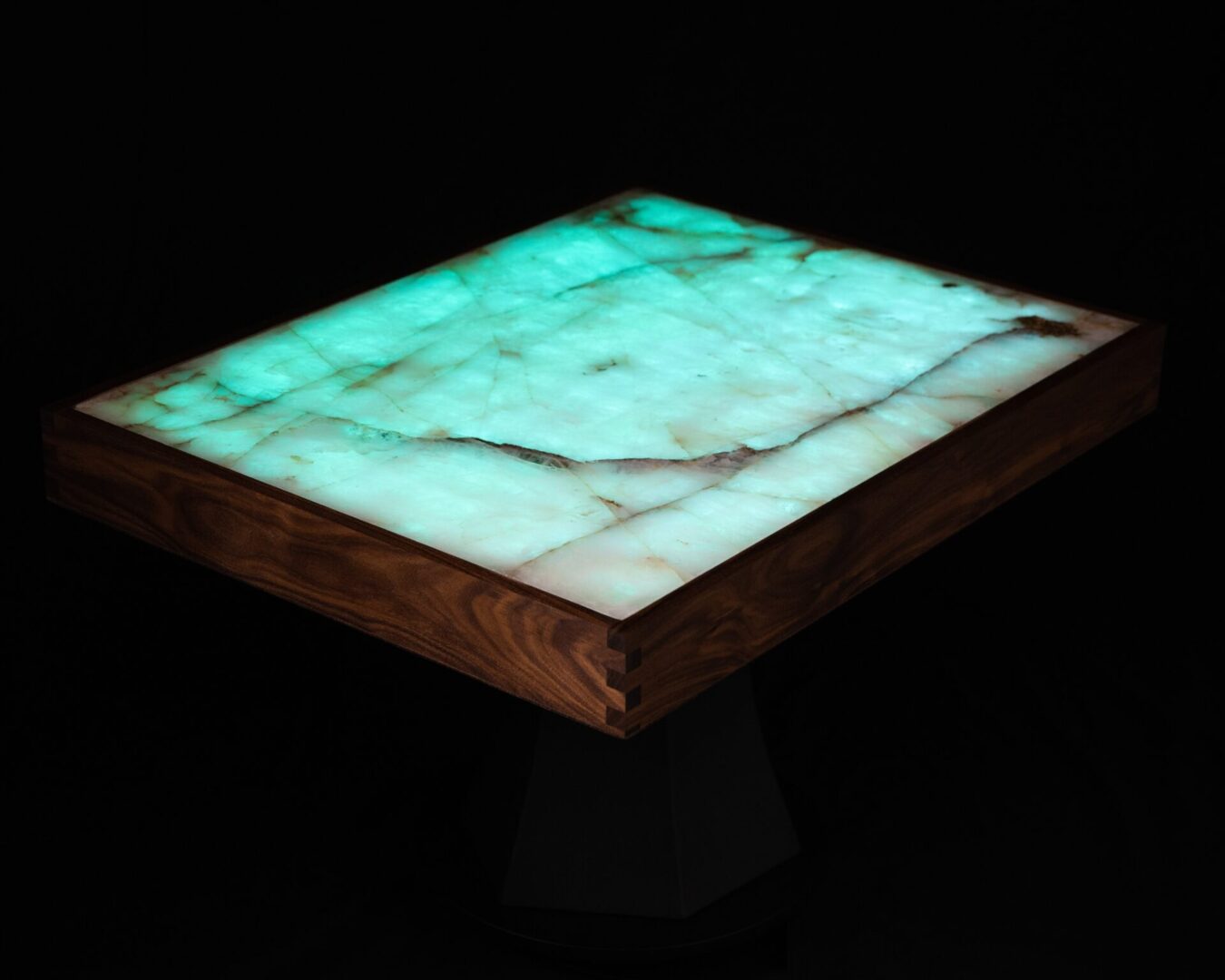 Glowing translucent table with a wooden frame in a dark setting.