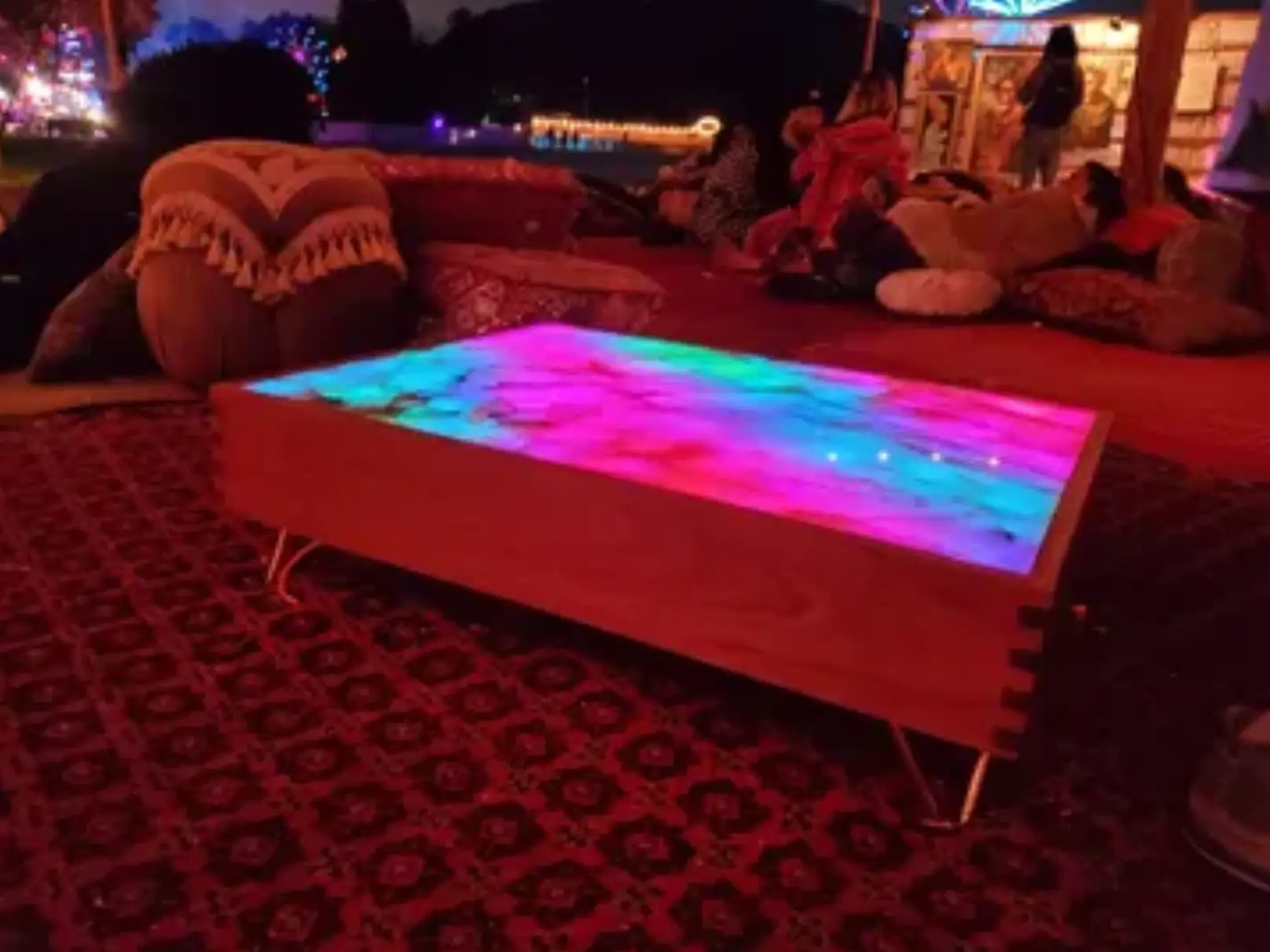 Colorful illuminated table on patterned rug.