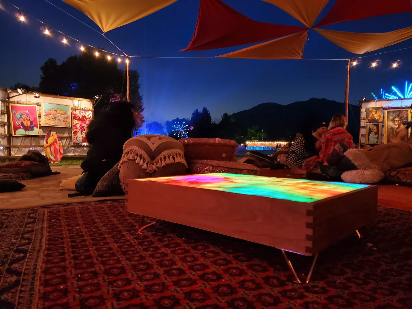 Outdoor lounge with colorful illuminated table.